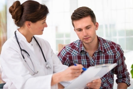 A doctor talking to her male patient during an office visit