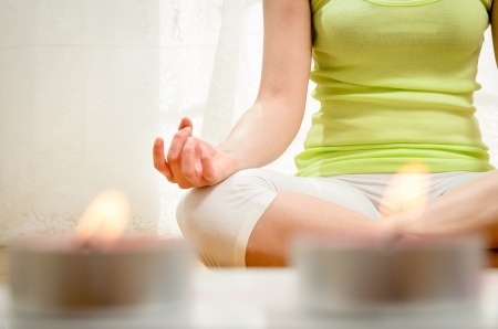 Woman meditating at home, preparing for her first visit with a gastroenterologist