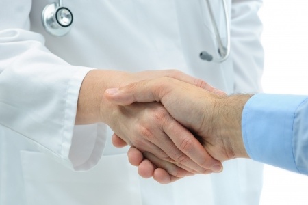 A doctor and his patient shaking hands