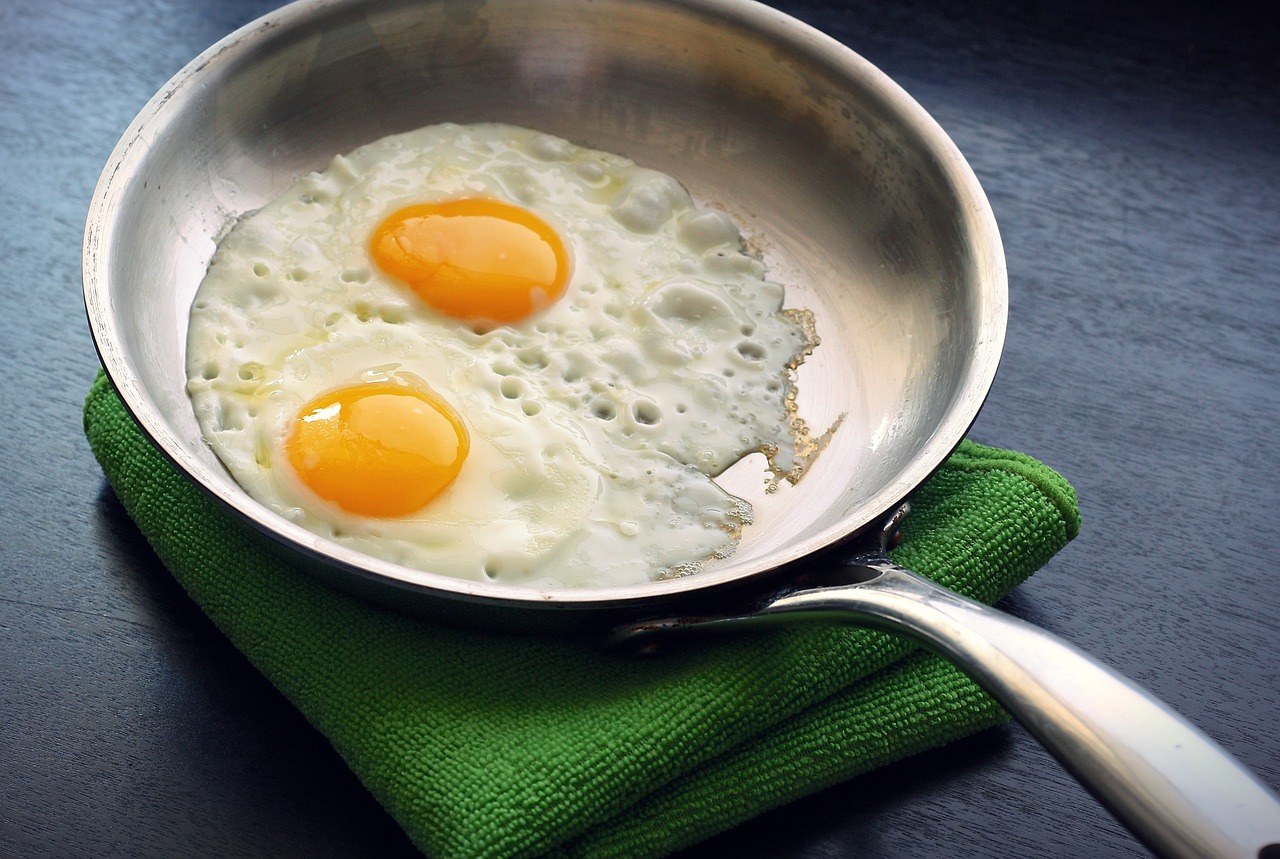 A photo of two eggs in a frying pan. During the elimination phase of this autoimmune diet, eggs are removed from the diet.
